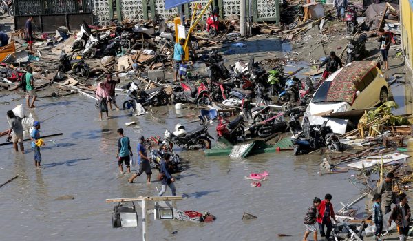 People survey outside the shopping mall which was damaged following earthquakes and a tsunami in Palu, Central Sulawesi, Indonesia, Sunday, Sept. 30, 2018. Rescuers try to reach trapped victims in collapsed buildings after hundreds of people are confirmed dead in a tsunami that hit two central Indonesian cities, sweeping away buildings with massive waves. (AP Photo/Tatan Syuflana)